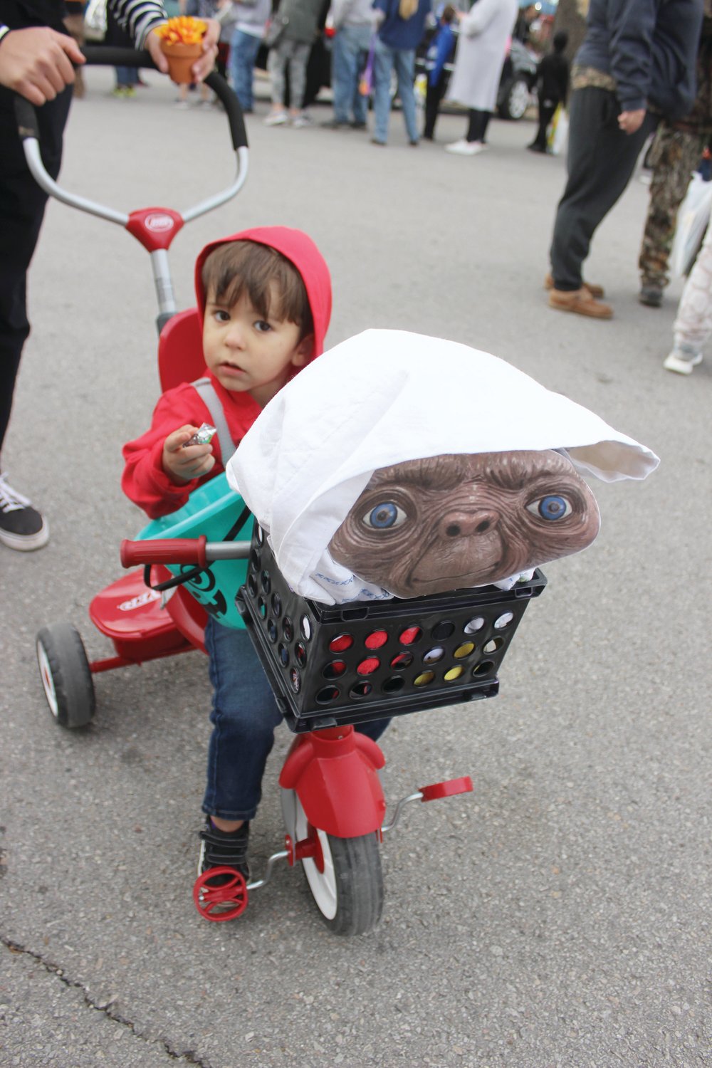 Young Thatcher Felton pedals his tricycle around the square with ET in his basket.